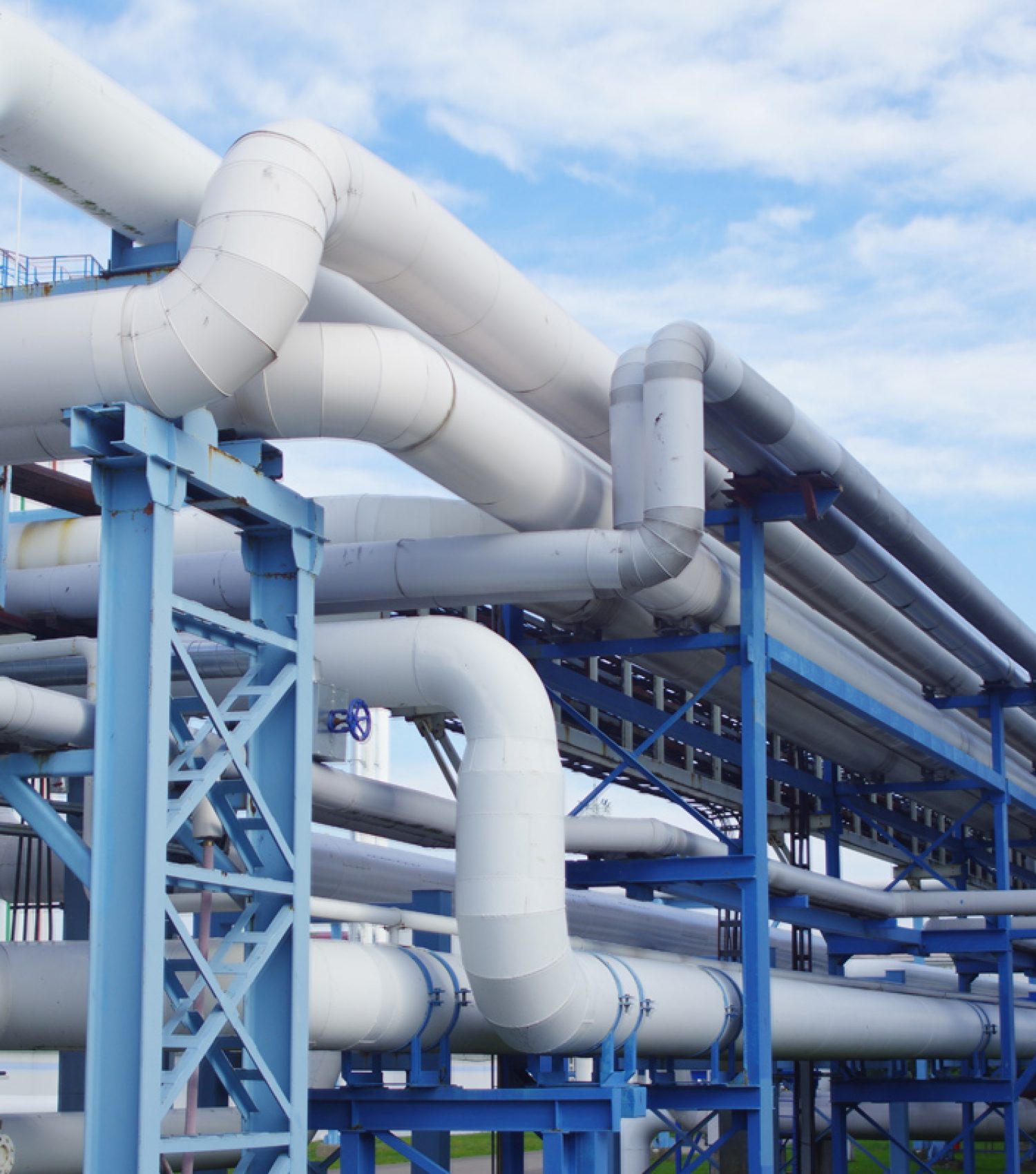 Closeup of industrial pipelines around a factor on a sunny day A closeup of industrial pipelines around a factor on a sunny day