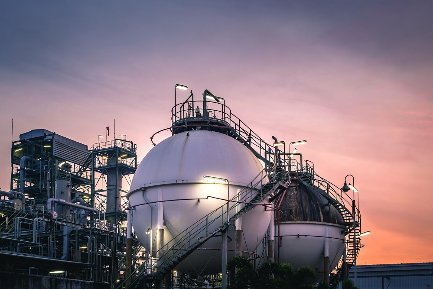 Gas storage sphere tanks in factories on sunset sky background Gas storage sphere tanks in factories on sunset sky background