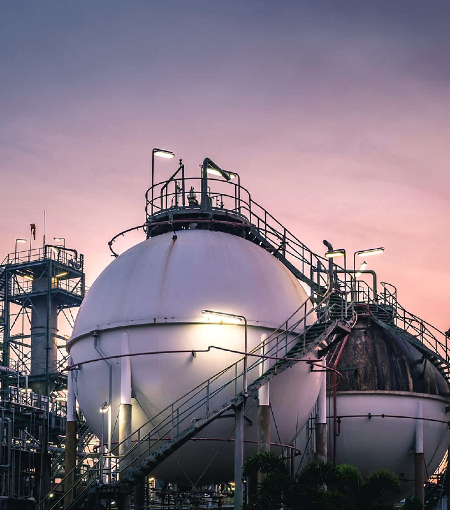 Gas storage sphere tanks in factories on sunset sky background Gas storage sphere tanks in factories on sunset sky background