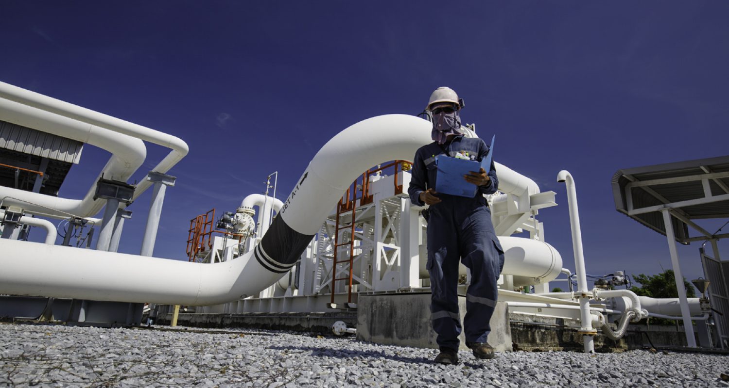 Male worker inspection at steel long pipes and pipe elbow in sta Male worker inspection at steel long pipes and pipe elbow in station oil factory during refinery valve of visual check record pipeline oil and gas industry